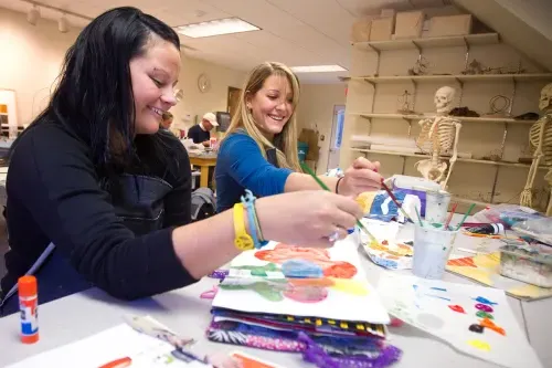 Two art students painting in class